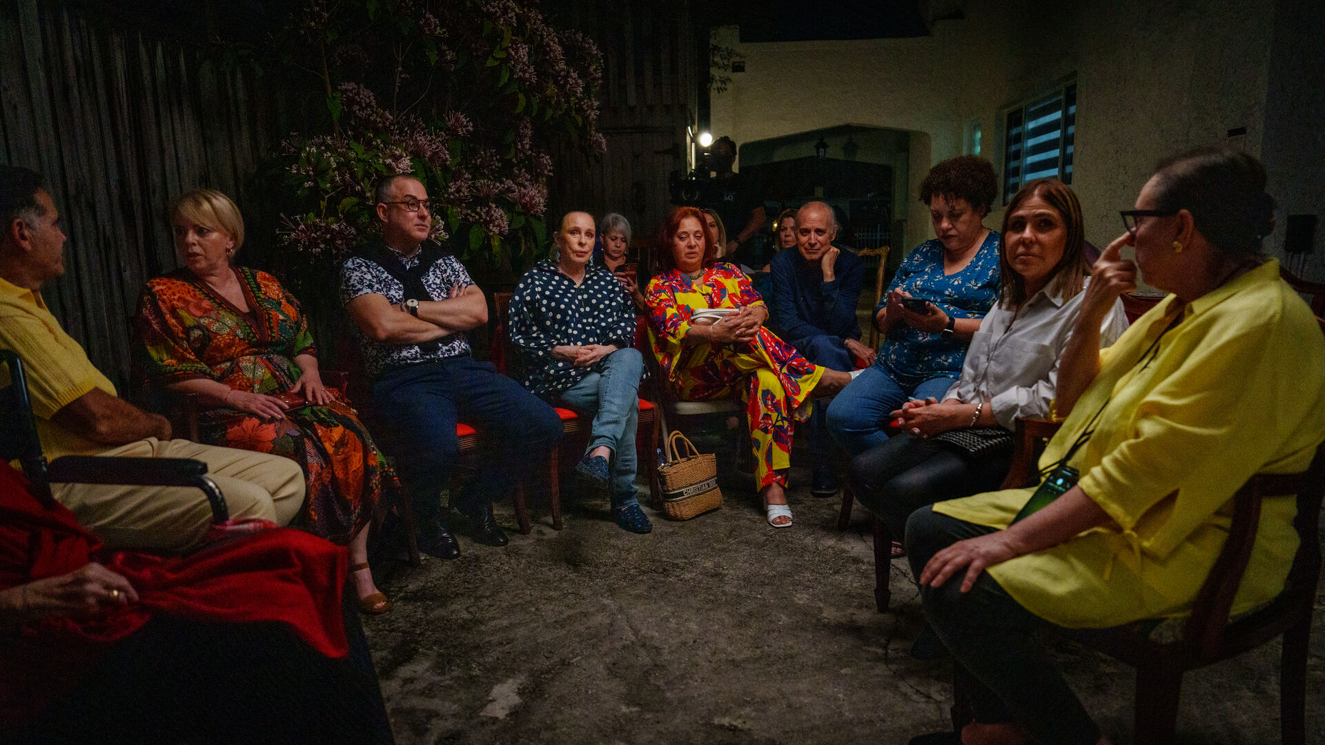 Community seated outdoors for evening gathering